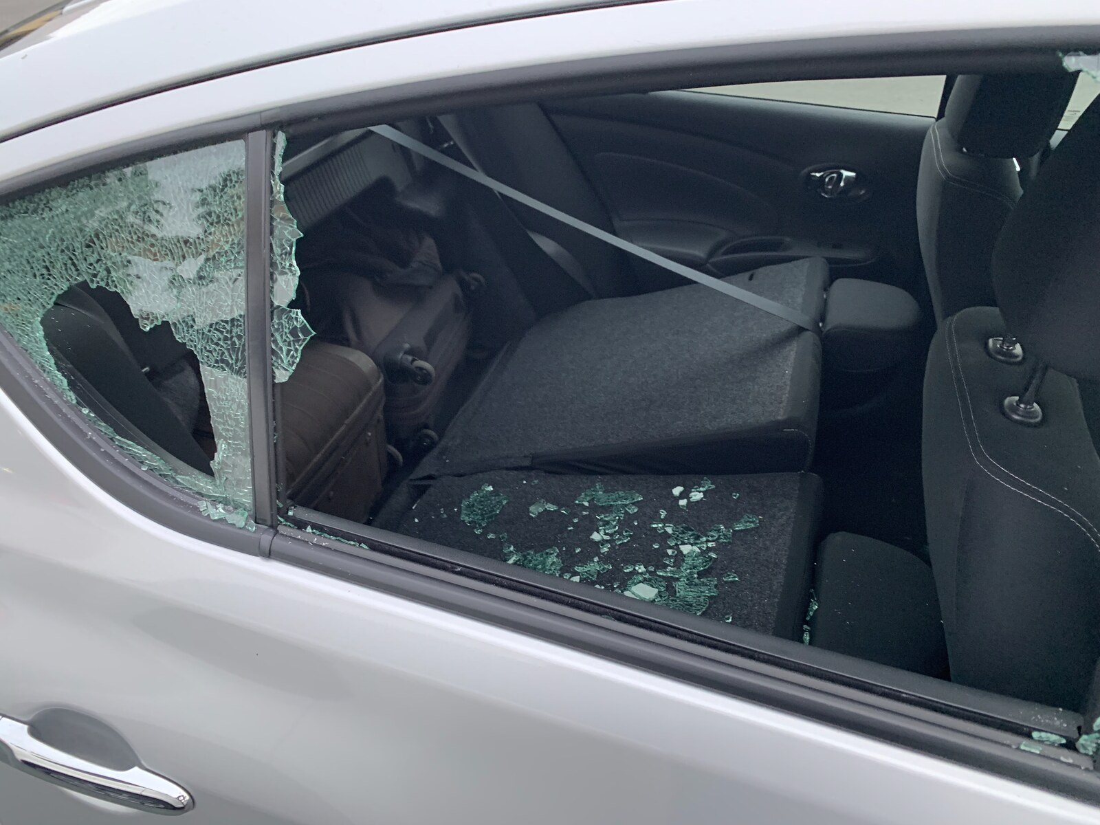The same car the next morning, back-side window smashed in, glass shards across the seat. The bags and laptops were gone.